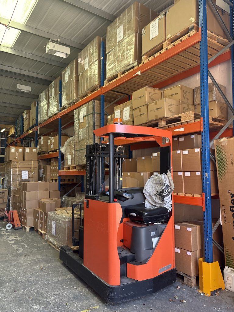 Reach truck for moving palletised stock in the warehouse